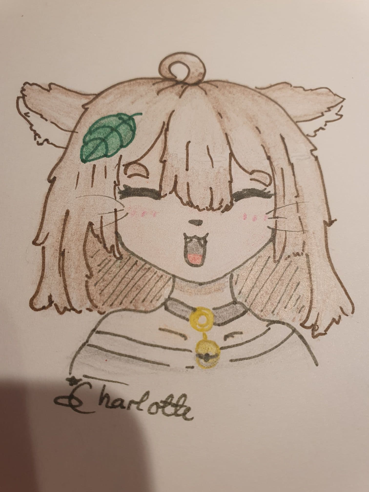 A photo of a drawing of a smiling, brown-haired catgirl with a realistic basil leaf in her hair. She's wearing a cat collar with a bell, and a gray off-the-shoulder top.